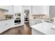 Bright white kitchen featuring modern stainless steel appliances and a view to the dining room with elegant chandelier at 4270 Aviemore Run, Burlington, NC 27215