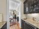 Elegant bar area with granite counters, glass cabinets and wine cooler, open to dining room at 432 Nickel Creek Cir, Cary, NC 27519