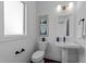 Powder room featuring pedestal sink, modern fixtures, and decorative art, creating a stylish space at 5 Bart St, Raleigh, NC 27610