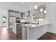 Bright kitchen featuring an island, pendant lights, and modern appliances, adjacent to a spacious living area at 5 Bart St, Raleigh, NC 27610