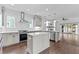 Bright kitchen featuring an island, modern stainless steel appliances, and seamless access to the living room with fireplace at 5 Bart St, Raleigh, NC 27610