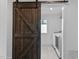 Laundry room featuring a rustic sliding barn door and modern washer and dryer at 5 Bart St, Raleigh, NC 27610