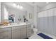 Well-lit bathroom featuring double sink vanity, large mirror, and stylish striped shower curtain at 516 Ivy Arbor Way, Holly Springs, NC 27540