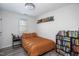 Neutral-toned bedroom with a full size bed, a bookshelf, and bright light from a window at 5417 Walton Hill Rd, Knightdale, NC 27545