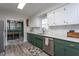 Well-lit kitchen with green cabinets, stainless steel appliances, and a view into the dining room at 5417 Walton Hill Rd, Knightdale, NC 27545