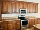 Gleaming stainless steel appliances among wood cabinets and granite countertops at 5740 Lemon Springs Rd, Sanford, NC 27332