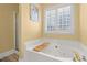 Relaxing bathroom with large soaking tub, glass block window, and separate shower at 610 Brownstone Rd, Gibsonville, NC 27249