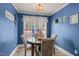 Charming dining room with blue walls, hardwood floors, and modern chandelier at 610 Brownstone Rd, Gibsonville, NC 27249