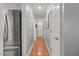 Hallway leading to bedrooms with hardwood floors and a stainless steel refrigerator at 610 Brownstone Rd, Gibsonville, NC 27249