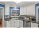 Bright kitchen featuring white cabinets, stainless steel dishwasher and decorative backsplash at 610 Brownstone Rd, Gibsonville, NC 27249