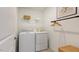 Well-organized laundry room featuring a full-size washer and dryer, storage shelves, and hanging rack at 627 Contento Ct, Sanford, NC 27330