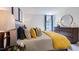Comfortable main bedroom showcasing a large window, modern dresser, and a stylish round mirror at 627 Contento Ct, Sanford, NC 27330