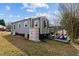 Home exterior features gray siding, white trim, shed and pergola in backyard at 704 Dothan Ave, Burlington, NC 27217