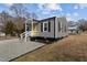 Side view of a cozy home with gray siding, black trim and a bright yellow door at 704 Dothan Ave, Burlington, NC 27217