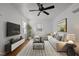 Bright living room featuring hardwood floors, a ceiling fan, and a comfortable sectional sofa at 704 Dothan Ave, Burlington, NC 27217