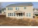 The home has a back patio with a grassy backyard and many windows for natural light at 800 Tree Green Ln, Wake Forest, NC 27587