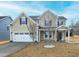 Charming home featuring a two-car garage, a well-manicured lawn, and a welcoming front porch at 800 Tree Green Ln, Wake Forest, NC 27587