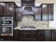 Modern kitchen features dark wood cabinets, stainless steel appliances, and granite countertops at 800 Tree Green Ln, Wake Forest, NC 27587