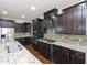 Gourmet kitchen featuring granite countertops, stainless steel appliances, and dark wood cabinetry at 800 Tree Green Ln, Wake Forest, NC 27587