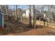 Landscaped backyard with a wooden fence, mature trees, and a rock pathway at 886 Drogheda Pl, Wake Forest, NC 27587