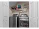Efficient laundry area with stainless steel washer and dryer, and plenty of shelving for storage at 886 Drogheda Pl, Wake Forest, NC 27587
