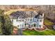 Aerial view of the exterior of a well maintained white brick house, featuring a large yard, two patios, and a spacious deck at 1002 Pleasant Dr, Mebane, NC 27302