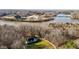 Aerial view of a charming home with a circular driveway surrounded by trees and a river in the background at 1002 Pleasant Dr, Mebane, NC 27302