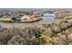 Aerial view of a charming home with a circular driveway surrounded by trees and a river in the background at 1002 Pleasant Dr, Mebane, NC 27302