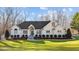 Attractive white brick home with a well-maintained lawn, groomed shrubbery, and a welcoming front entrance at 1002 Pleasant Dr, Mebane, NC 27302