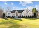 Charming white brick home with a manicured lawn, mature trees and an inviting entrance with white pillars at 1002 Pleasant Dr, Mebane, NC 27302