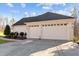 Spacious two-car garage with white doors, exterior lighting and concrete driveway at 1002 Pleasant Dr, Mebane, NC 27302