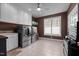 A laundry room with stainless steel appliances, storage cabinets, and a workspace for folding at 1002 Pleasant Dr, Mebane, NC 27302