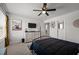 Bright bedroom with a black metal bed frame, carpet flooring, ceiling fan, and a decorative cow wall art at 1020 Broadlands Way, Graham, NC 27253