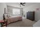 Neutral bedroom with a pink quilt, ceiling fan, and carpet flooring at 1020 Broadlands Way, Graham, NC 27253