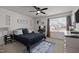 Well-lit bedroom with a black metal bed frame, ceiling fan, and decor with neutral color palette at 1020 Broadlands Way, Graham, NC 27253