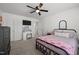 Bright bedroom with a pink quilt, ceiling fan, and carpet flooring at 1020 Broadlands Way, Graham, NC 27253