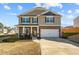 Charming two-story home featuring a stone facade, covered porch, and a two-car garage at 1020 Broadlands Way, Graham, NC 27253