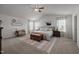 Bright primary bedroom with high ceilings, a cow wall art, lots of natural light, and an upholstered bed at 1020 Broadlands Way, Graham, NC 27253