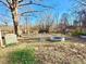 Expansive backyard featuring a stone fire pit, mature trees, and potential for outdoor activities at 1043 Cavel Chub Lake Rd, Roxboro, NC 27574