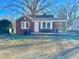 Charming one-story brick home featuring a covered carport and an American flag at 1043 Cavel Chub Lake Rd, Roxboro, NC 27574