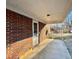 Outdoor patio featuring a covered porch, brick exterior, and space for outdoor seating and relaxation at 1043 Cavel Chub Lake Rd, Roxboro, NC 27574