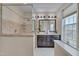 Bathroom featuring a tiled shower, double sink vanity with dark wood cabinetry, and large window at 10510 Sablewood Dr # 114, Raleigh, NC 27617