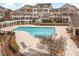 Aerial view of a community pool with lounge area, walking path, and townhome buildings, providing a resort-like experience at 10510 Sablewood Dr # 114, Raleigh, NC 27617