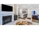 Open concept living room featuring a fireplace, mounted TV, and view to the eat-in kitchen with modern appliances at 106 N Finley Landing Pkwy # 1, Smithfield, NC 27577