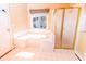 Bright bathroom features a large tub, glass shower, and window bringing in lots of natural light at 10620 Staghound Trl, Zebulon, NC 27597
