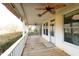 Inviting covered porch with ceiling fans and a view of well-maintained yard at 10620 Staghound Trl, Zebulon, NC 27597
