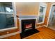 Cozy fireplace with black trim nestled between bright windows and hardwood floors that accentuates the inviting space at 10620 Staghound Trl, Zebulon, NC 27597