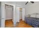 Bedroom with hardwood floors, a ceiling fan, double closet, and view into ensuite bathroom at 1107 S 2Nd St, Smithfield, NC 27577