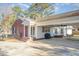 Charming brick and white home featuring an outdoor patio with built-in seating and covered grilling area at 1107 S 2Nd St, Smithfield, NC 27577