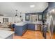 Modern kitchen featuring blue cabinets, stainless steel appliances, a breakfast bar, and hardwood floors at 1107 S 2Nd St, Smithfield, NC 27577